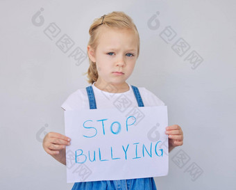 肖像伤心女孩持有停止欺凌标志可爱的小学岁的女孩伤心抗议欺凌