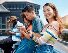 肖像美丽的年轻的微笑亚洲女人站朋友手机浏览互联网集团多样化的千禧一代手机连接社会梅迪
