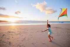 好玩的自然幸福女孩玩风筝海滩