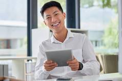 年轻的快乐亚洲商人社会媒体数字平板电脑坐着办公室工作中国人男人。微笑检查电子邮件数字平板电脑男人。发送消息平板电脑