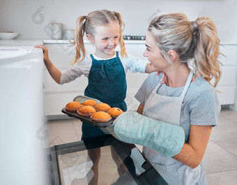 妈妈。女儿删除托盘松饼烤箱快乐女人烘焙松饼女儿女孩成键妈妈。烘焙父采取松饼烤箱
