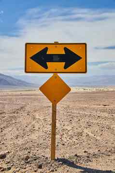 黄色的路标志十字路口左桑迪沙漠