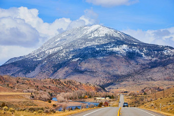 双车道铺路山领先的巨大的雪山西方美国