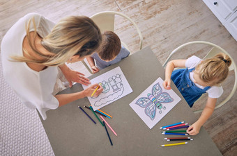 拍摄女孩男孩坐着表格色彩鲜艳的铅笔图片着色妈妈帮助高加索人妈妈。孩子们享受教育消遣有创意的