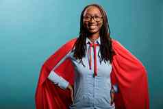 骄傲勇敢的超级英雄女人穿强大的英雄红色的角站蓝色的背景