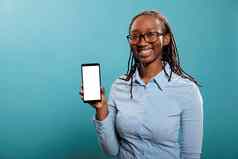快乐的微笑年轻的女人持有现代智能手机设备孤立的模型屏幕蓝色的背景