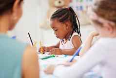 非洲美国女孩坐着表格着色学前教育幼儿园研究员学生年轻的女孩子色彩鲜艳的铅笔画图片教室学校