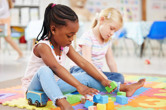 非洲美国女孩同学玩色彩鲜艳的教育玩具块地板上学前教育幼儿园孩子们有趣的订婚了有创意的学习发展