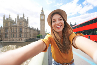 微笑旅游女孩采取肖像伦敦自拍照片快乐女人旅行伦敦大我塔西敏寺宫双德克尔红色的公共汽车夏天阳光明媚的一天