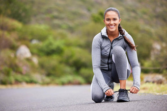 活跃的适合女人系鞋带运动鞋锻炼在户外运动员修复鞋子准备好了运行慢跑早....准备让人耳目一新有氧运动锻炼