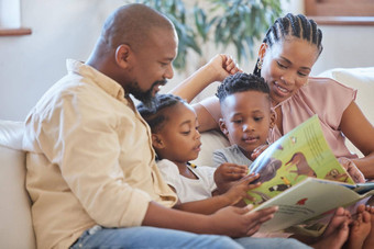 年轻的非洲美国家庭坐着沙发微笑阅读故事书首页