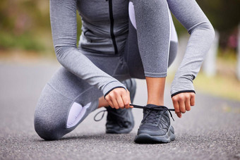 未知的适合女人系鞋带运动鞋锻炼在户外认不出来运动员修复鞋子准备好了运行慢跑早....准备让人耳目一新有氧运动锻炼