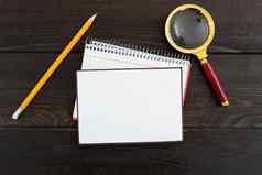 空白纸螺旋笔记本铅笔放大玻璃木背景空表文具表格显示重要的业务信息