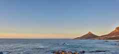 海洋视图海水岩石海滩山蓝色的天空复制空间狮子头角小镇南非洲平静潮宁静宁静的风景放松妈妈。自然日出