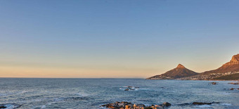 海洋视图海水岩石海滩山蓝色的天空复制空间狮子头角小镇南非洲平静潮<strong>宁静宁静</strong>的风景放松妈妈。自然日出
