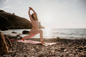 中间岁的女人黑色的头发普拉提环瑜伽席海卵石海滩女健身瑜伽概念<strong>健康</strong>的生活方式<strong>和谐</strong>冥想