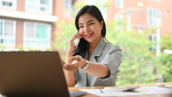 迷人的亚洲女商人咨询客户端手机移动PC电脑现代办公室