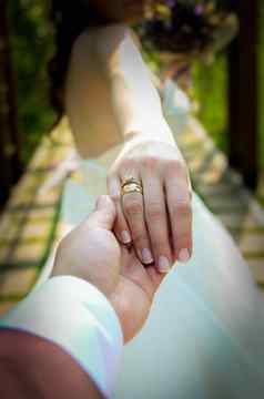 新娘新郎持有手订婚环手指关闭视图婚礼拍摄概念