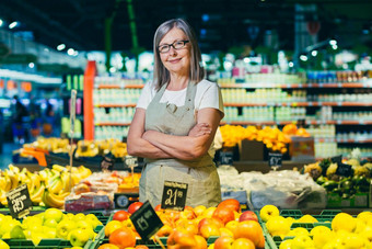 肖像高级头发花白的女人超市工人工人传播水果