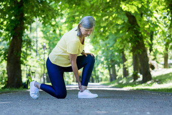 高级活跃的女人慢跑受伤的腿<strong>膝盖</strong>头发花白的养老金领取者夏天公园