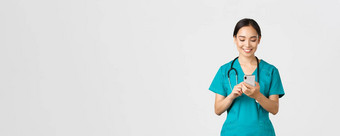 科维德医疗保健工人防止病毒概念微笑快乐美丽的亚洲女实习生医生使电话调用移动电话屏幕很高兴消息传递应用程序