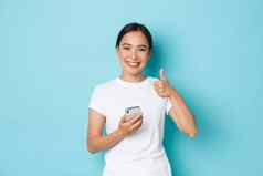 生活方式技术电子商务概念满意美丽的亚洲女客户客户端在线商店离开积极的反馈持有智能手机显示竖起大拇指手势
