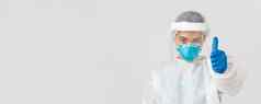 科维德冠状病毒疾病医疗保健工人概念严肃的表情自信亚洲女医生医生个人保护设备呼吸器显示竖起大拇指白色背景