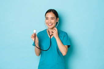 科维德社会距离冠状病毒流感大流行概念微笑友善的年轻的女医生实习生实习医生风云听病人肺听诊器光蓝色的背景