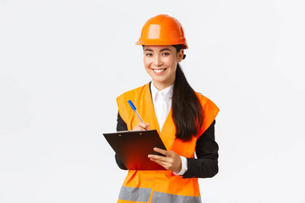 微笑满意亚洲女建设工程师领先的检查企业穿安全头盔反光夹克写作笔记很高兴结果白色背景