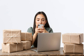 小业务主人启动电子商务概念可爱的亚洲女商人工作首页在线商店打字消息智能手机移动PC包装订单盒子