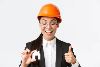 特写镜头快乐很高兴亚洲女架构师建设工程师头盔西装首页微型显示竖起大拇指保证质量维修作品白色背景