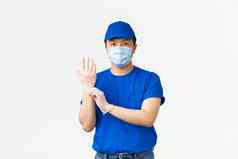 非接触式交付科维德航运防止病毒概念年轻的亚洲员工蓝色的快递统一的把保护手套将包客户白色背景