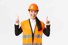 建筑建设工业概念成功的很高兴亚洲女工程师安全头盔检查对象指出手指满意架构师很高兴好结果