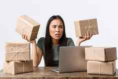 小业务主人启动电子商务概念沮丧生气亚洲女人坏一天工作包装货物在线商店航运坐移动PC愤怒的