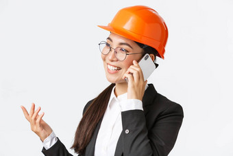 特写镜头专业微笑亚洲女企业家工厂首席工程师安全头盔西装会说话的电话业务谈话投资者企业
