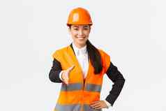自信成功的女架构师领袖建设安全头盔反光夹克extand手握手问候业务合作伙伴建筑区域站白色背景