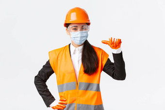 科维德安全协议企业建设防止病毒概念自信亚洲女工程师头盔脸面具指出做广告个人协助