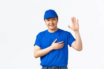 肖像微笑真诚的亚洲快递蓝色的统一的提高手手臂心使承诺护理客户包裹交付男人。使承诺站白色背景