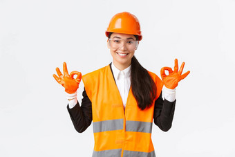 自信亚洲女建设工程师企业经理显示手势把安全头盔眼镜手套进入危险的区域白色背景