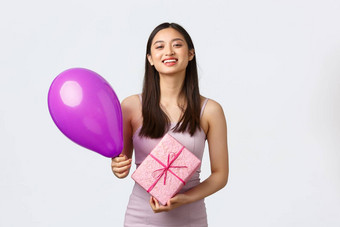庆祝活动聚会，派对假期概念美丽的亚洲女孩衣服庆祝生日持有气球生日礼物微笑感谢惊喜白色背景