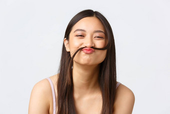 概念美时尚化妆产品广告特写镜头肖像快乐愚蠢的亚洲女孩使假的胡子头发海滩微笑快乐的白色背景