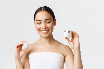 美个人护理水疗中心沙龙护肤品概念特写镜头美丽的亚洲女浴毛巾持有面霜眼睛脸滋养产品微笑皮肤治疗