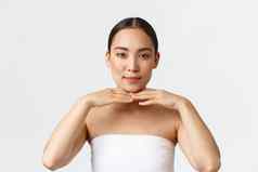 美美容水疗中心沙龙概念美丽的温柔的亚洲女客户端美诊所穿毛巾触碰下颌的轮廓显示清洁完美的皮肤做广告面部产品