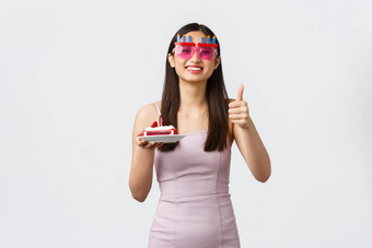 庆祝<strong>活动聚</strong>会，派对假期概念快乐的微笑亚洲女人眼镜衣服显示竖起<strong>大</strong>拇指庆祝生日使生日蛋糕白色背景