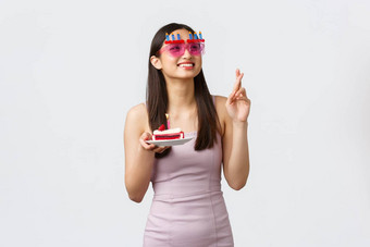 庆祝活动聚会，派对假期概念美丽的梦幻亚洲女孩有趣的太阳镜交叉手指生日蛋糕使微笑快乐上角落里