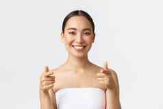 美美容水疗中心沙龙概念特写镜头有吸引力的亚洲女人毛巾微笑快乐指出手指相机推荐访问美诊所白色背景