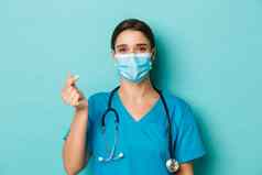 概念科维德检疫概念快乐的美丽的女医生实习医生风云医疗面具显示心标志站蓝色的背景