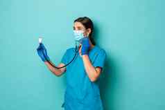 科维德流感大流行医学概念美丽的女医生医疗面具手套实习医生风云病人检查听诊器检查肺站蓝色的背景