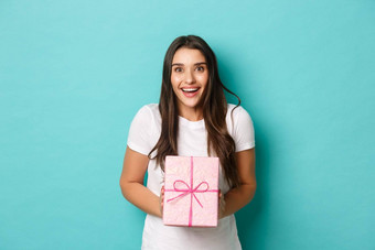概念假期庆祝活动图像兴奋女人快乐微笑接收礼物包装粉红色的盒子站蓝色的背景