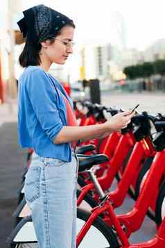 年轻的女人电话解锁租赁自行车